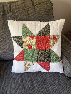 a pillow on a couch with a star quilted onto it's back end