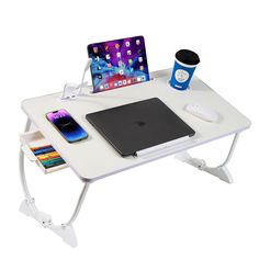 a white table with a laptop and other items on it