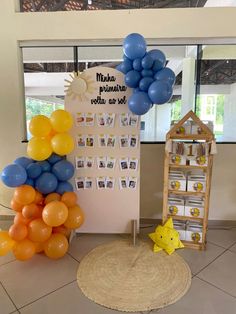 balloons are arranged on the floor in front of a bulletin board with pictures and photos