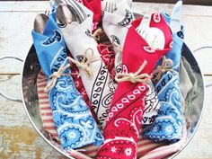 a metal bowl filled with colorful napkins and silverware