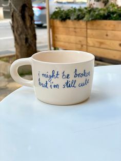 a white coffee cup sitting on top of a table