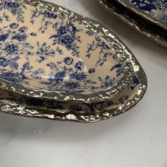 three blue and white plates sitting on top of a table next to each other,