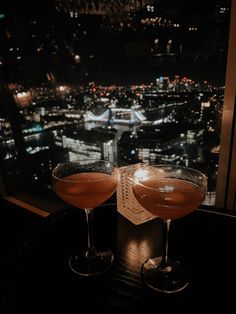 two cocktails sitting on top of a table next to each other with the words dinner at the shard, london