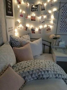 a bedroom with lights strung from the ceiling and pictures on the wall above the bed