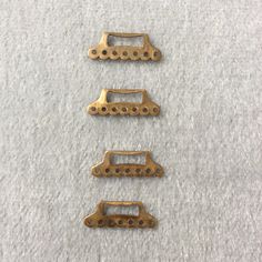 three brass colored metal clips on white carpet