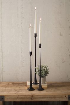 three candles are sitting on a wooden table