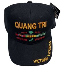 a black hat with the words quanng tri written on it and two medals around the brim