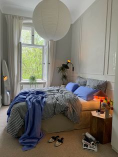 a bed room with a neatly made bed next to a window