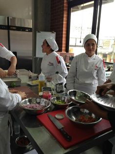 four chefs are preparing food in the kitchen