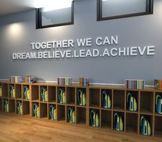 there are many bookshelves in front of the wall that says together we can dream believe lead achieve