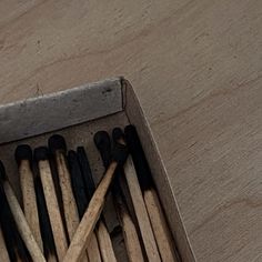 a box filled with lots of matches on top of a wooden table