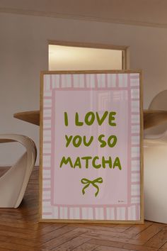 a sign that says i love you so matcha in green lettering on a pink background