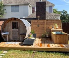 an outdoor hot tub in the middle of a backyard with a deck and patio furniture