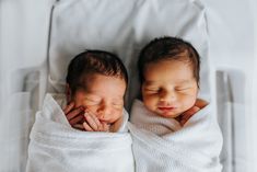 two newborn babies wrapped in white blankets