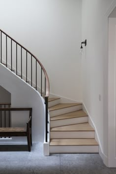 there is a stair case next to the bannister in this house with white walls