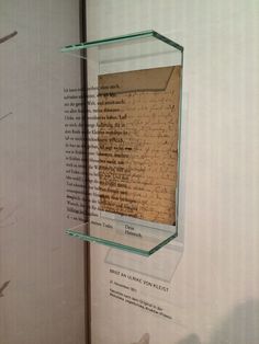 a piece of paper with writing on it in a glass case