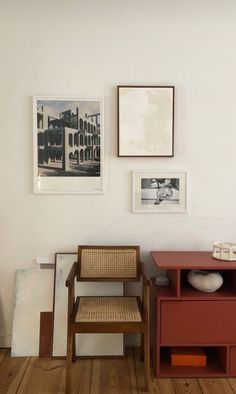 two chairs and a table in a room with pictures on the wall