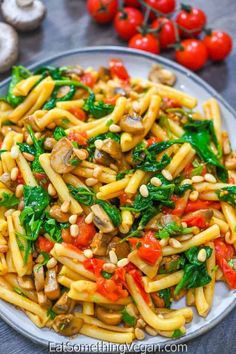 pasta with mushrooms, spinach and tomatoes on a plate