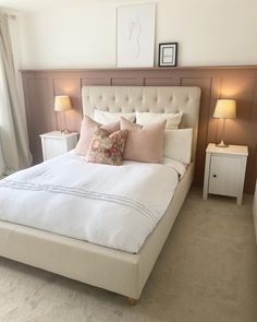 a bed with white linens and pillows in a bedroom next to two nightstands