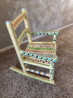 a child's wooden rocking chair on carpeted floor