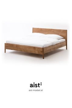 the bed frame is made from wood and has white sheets