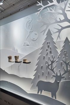 an image of a window display with shoes and deer in the snow on it's side