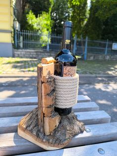 a wine bottle holder made out of wood and rope