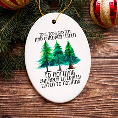 a christmas ornament hanging from a tree on top of a wooden table next to ornaments