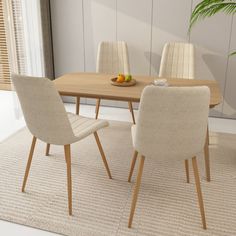 a dining room table with chairs and a bowl of fruit on it