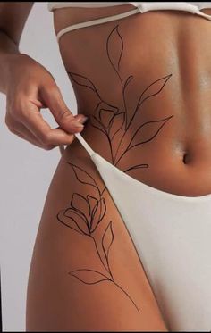 a woman is showing off her stomach with flowers on it