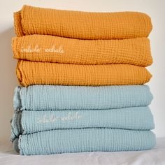 four folded towels stacked on top of each other in different colors and sizes, with the words'comforter bedcloths'written across them