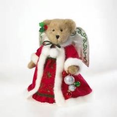 a teddy bear dressed as santa clause holding a christmas ornament in its hand