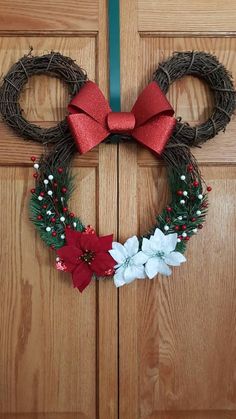 a mickey mouse wreath with red bow and poinsettis on the front door