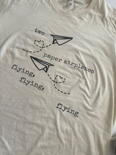 a t - shirt with two paper airplanes flying on it