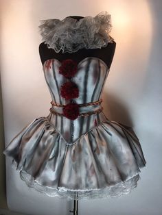 a mannequin is dressed in silver and red with flowers on the bustle