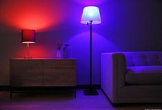 a living room with purple lighting and a white couch