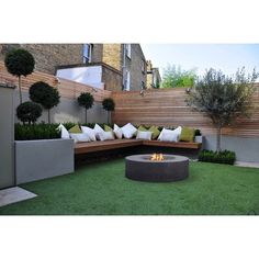 an outdoor fire pit surrounded by grass