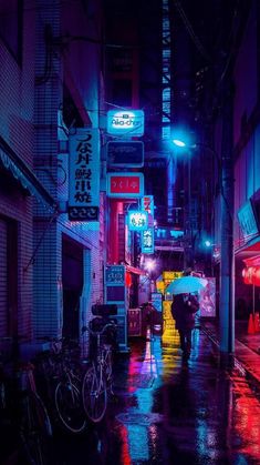 two people walking down the street in the rain at night with umbrellas open and signs lit up