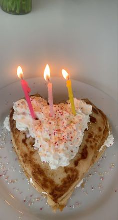 there is a heart shaped cake with candles in the shape of a heart on a plate