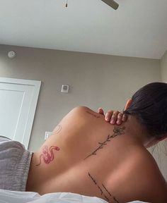 a woman laying on top of a bed next to a ceiling fan