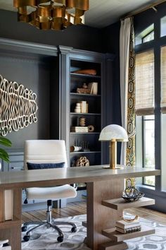 an office with a desk, chair and bookcase in front of large open windows