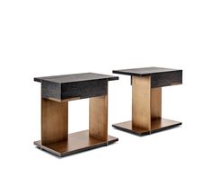 two black and gold side tables sitting next to each other on top of wooden bases