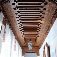 an ornate ceiling in the middle of a room with white walls and wooden trimmings