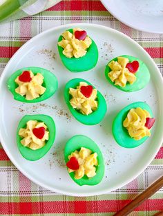 there are some cupcakes with yellow frosting and red hearts in them on a white plate