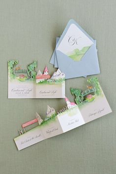 the wedding stationery is laid out on top of each other, including envelopes and cards