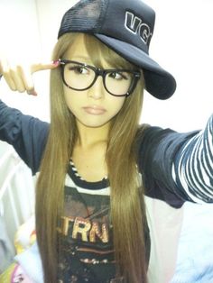 a girl with long hair wearing glasses and a hat