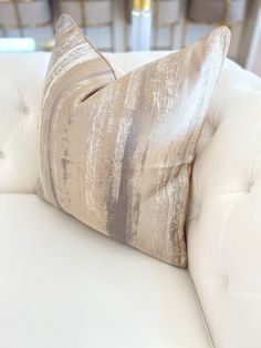 a close up of a white couch with a pillow on it's backrest