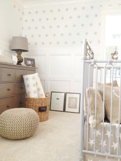 an image of a baby's room with stars on the wall and pictures on the dresser