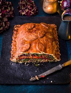 a large piece of food sitting on top of a cutting board next to a knife