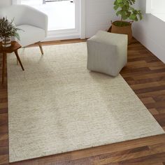 a living room with a chair, ottoman and rug